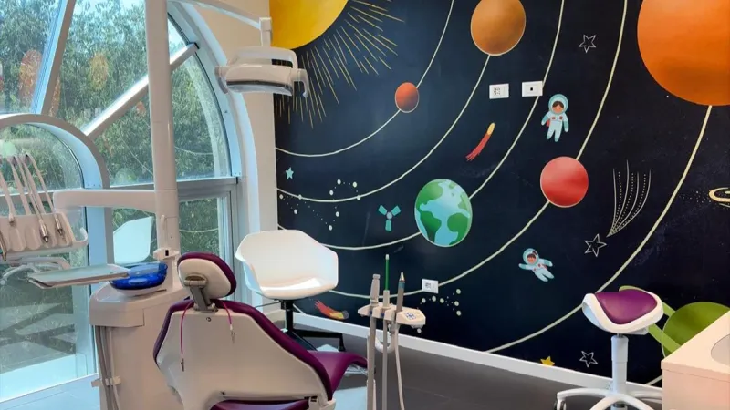 Area gioco con giochi e tappeto morbido - Studio dentistico bambini Abracadabra - Giallo Pastello Interior Design