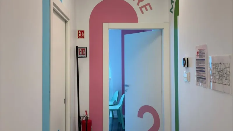 Sala visite luminosa con pareti decorate - Studio dentistico bambini Abracadabra - Giallo Pastello Interior Design